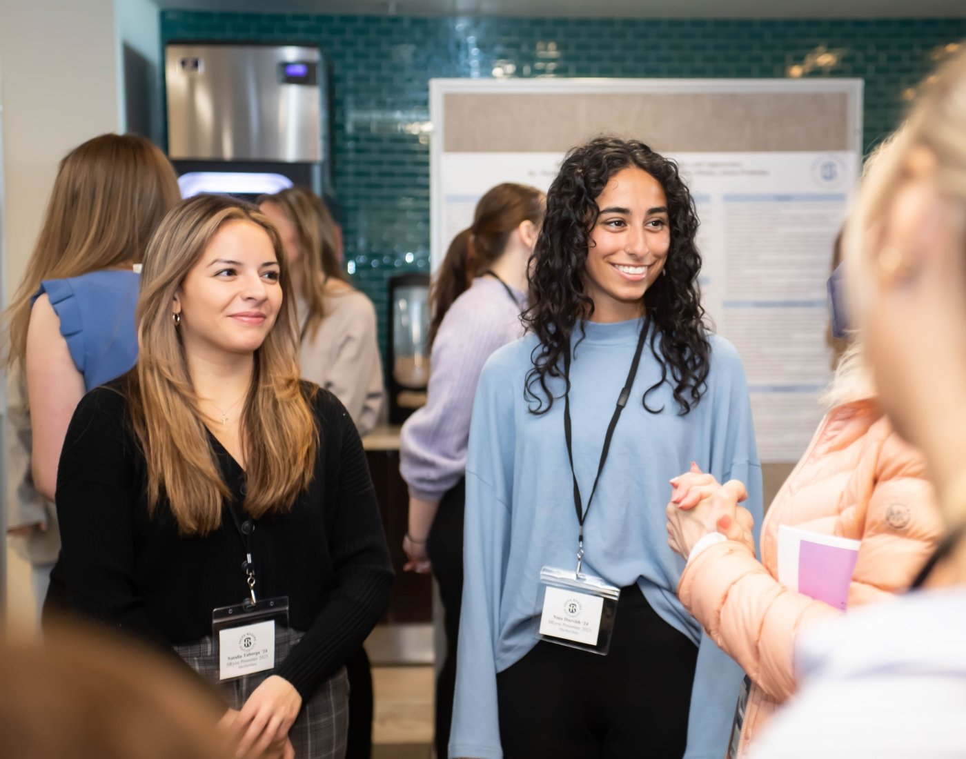 Two students presenting their research to professional audience