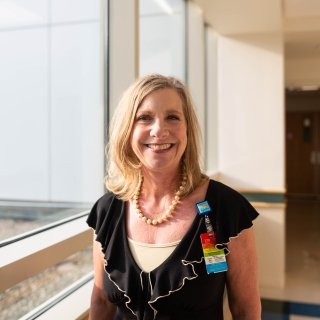 Beth welborn headshot standing by a sunny window