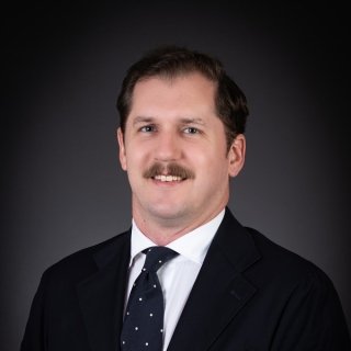 Headshot of alum Terence Nicholas in a suit and tie