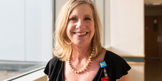 Beth welborn headshot standing by a sunny window
