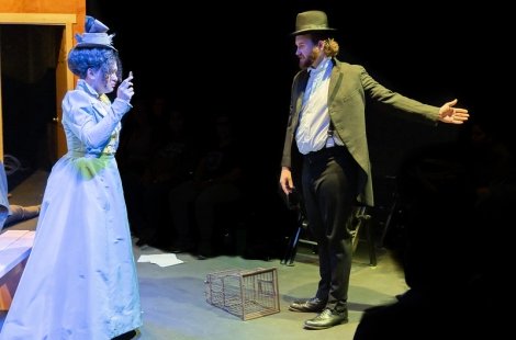 Man and women in period costumes in an animated conversation