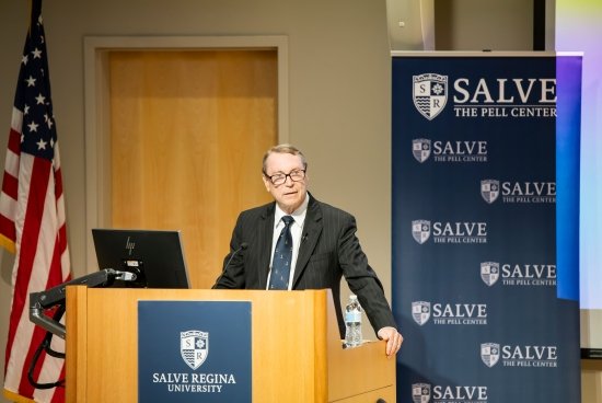 Craig Symonds standing at a podium giving his McGinty Lecture, with Salve branding and an American flag behind him.