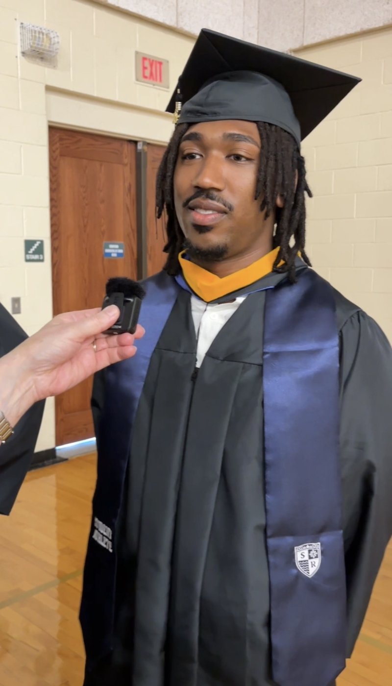 A man wearing a graduation cap and gown