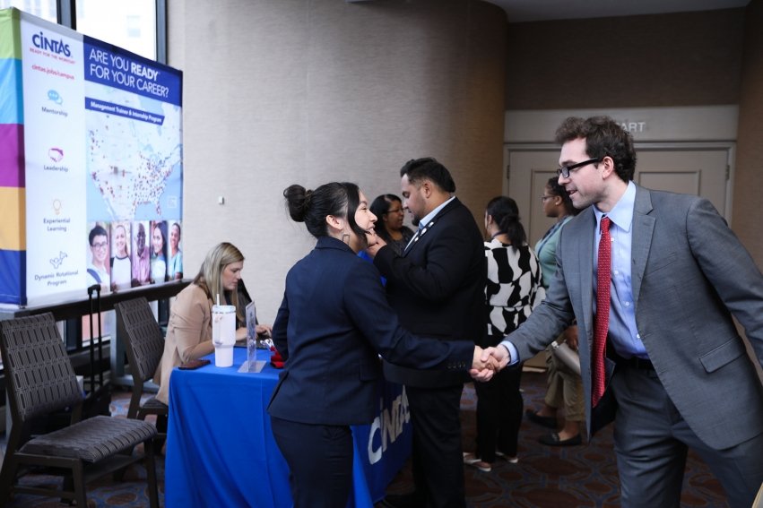Student Ben Wakefield shaking hands with woman at the AMA ICC career fair.